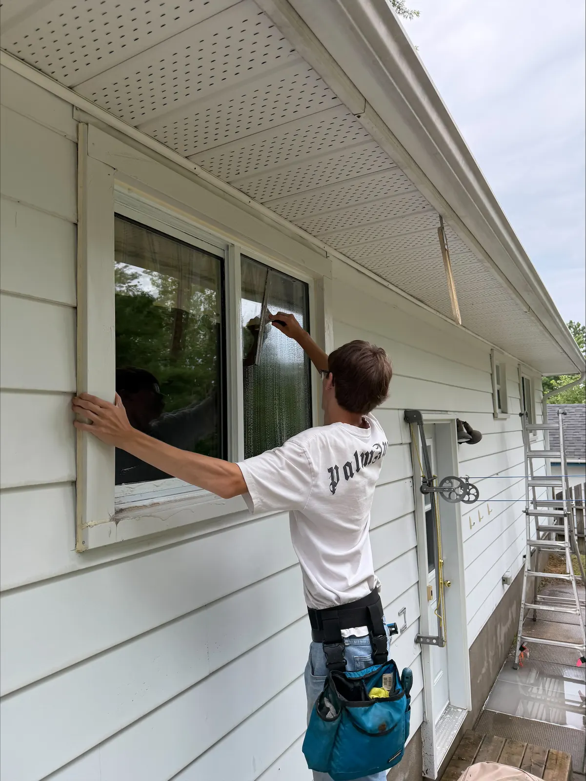 Crew member squeegeeing an exterior window of a bungalow in Petawawa