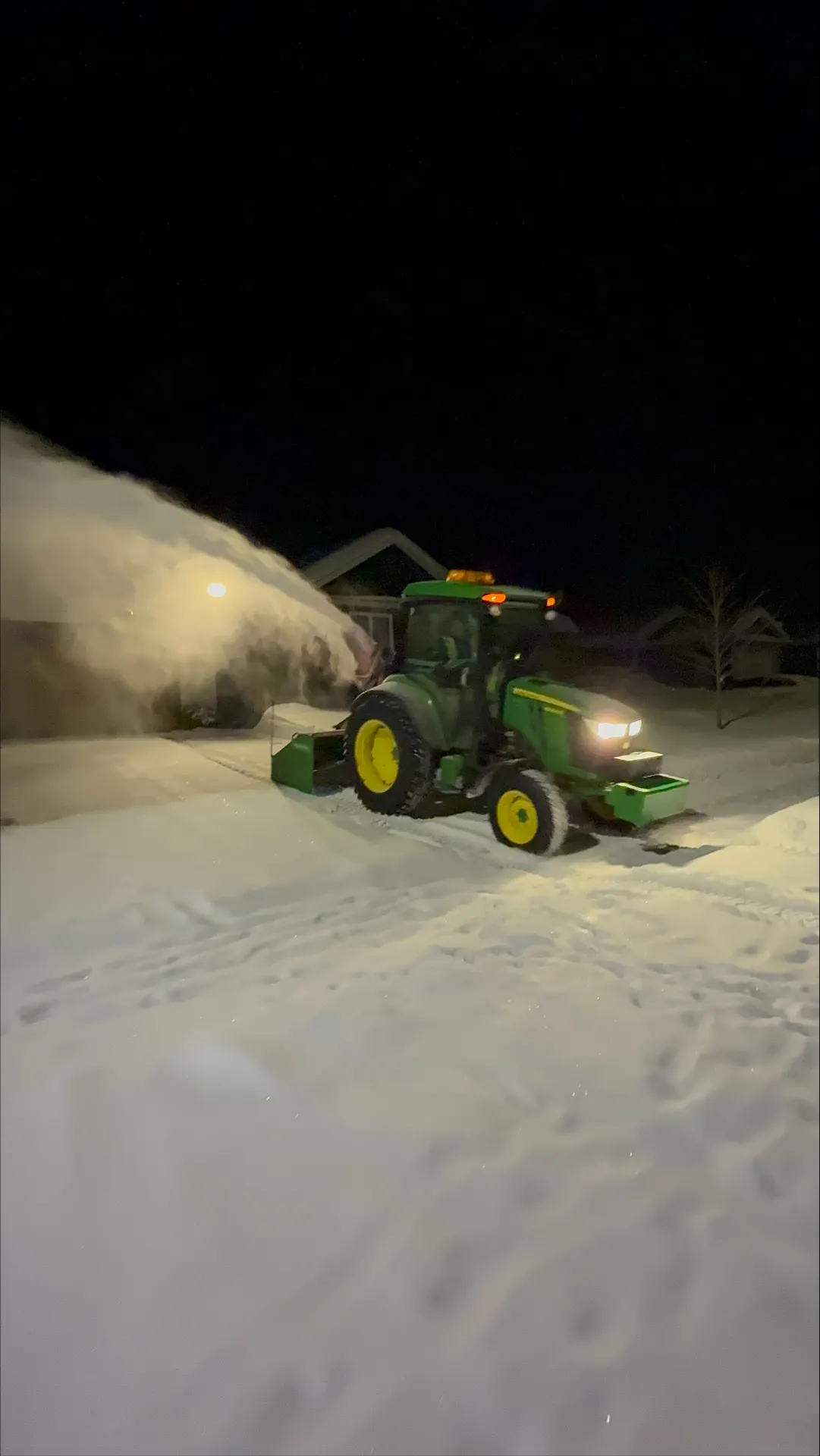 Tractor throwing an arc of snow during a night clearing run in the Ottawa Valley