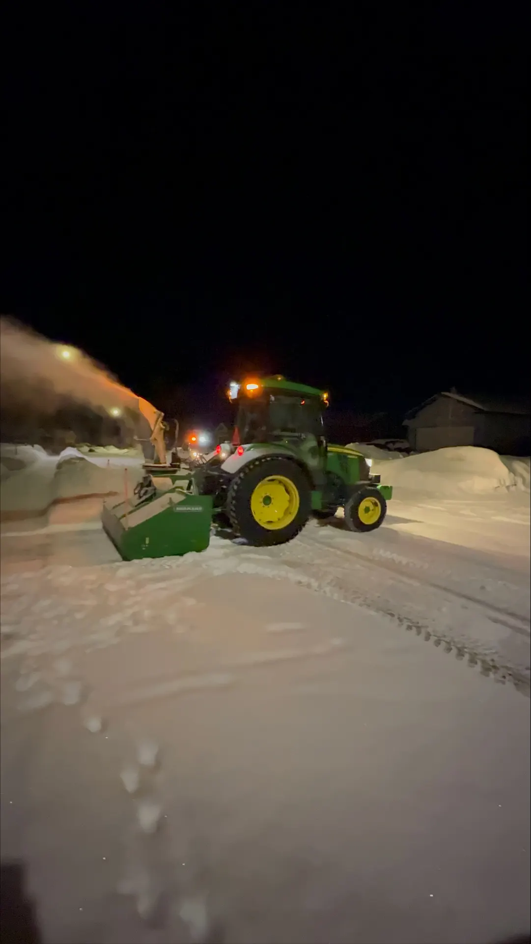 PVS tractor snow-blowing along a residential street at night in Petawawa