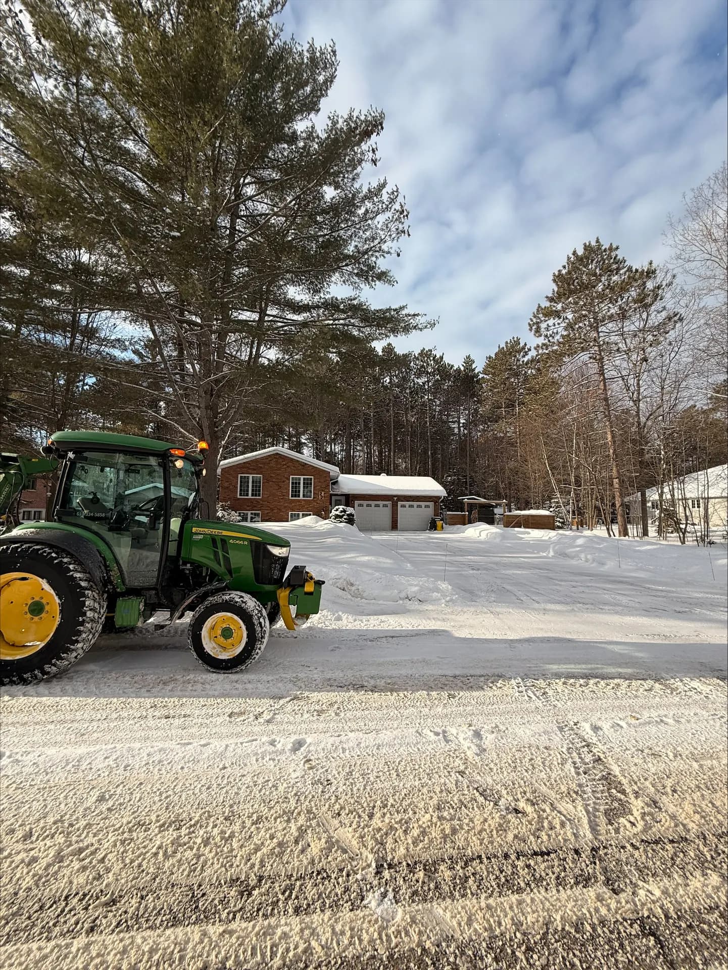 PVS tractor beside a freshly cleared residential driveway on a sunny winter day in Petawawa