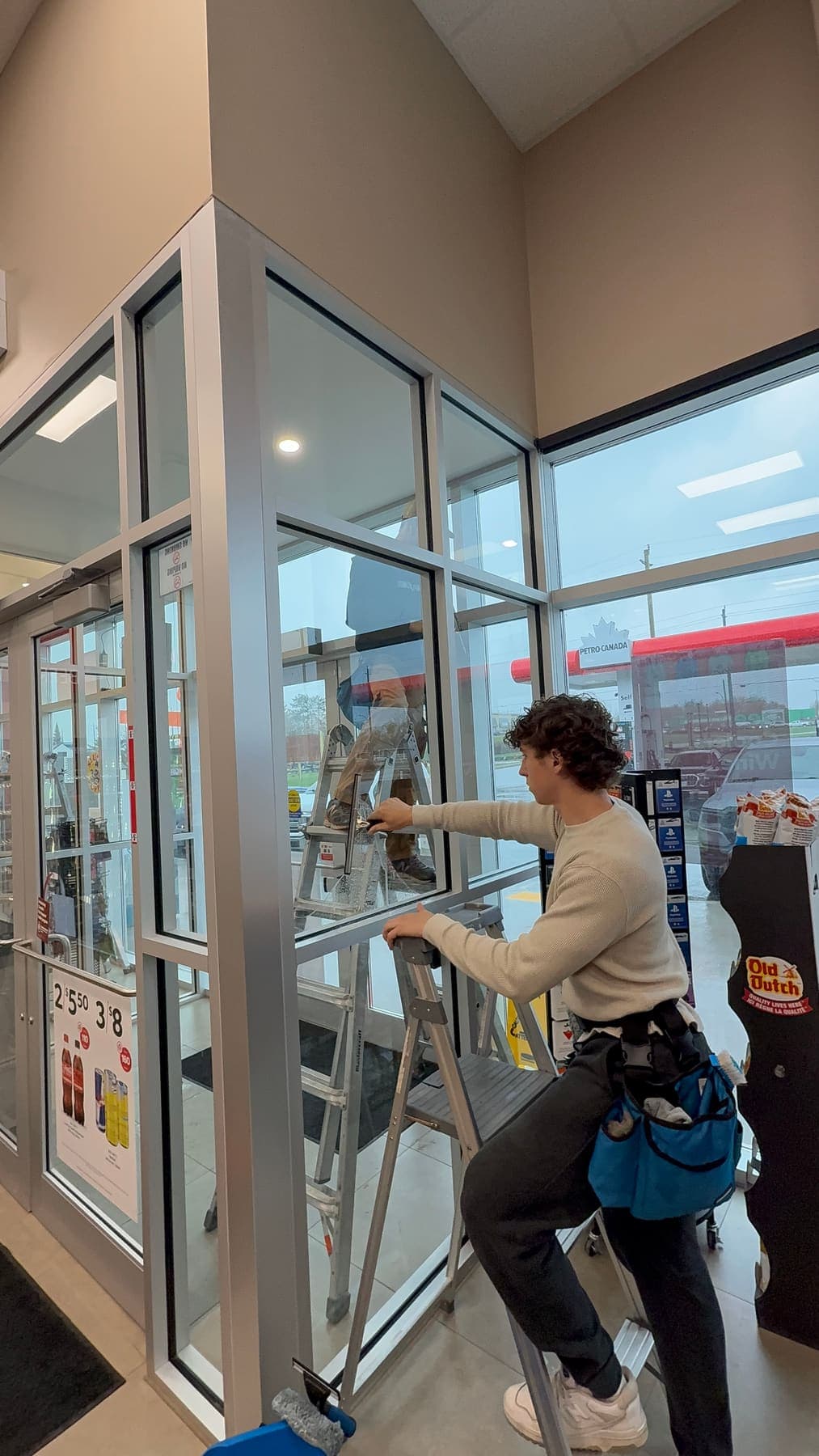 PVS technician squeegeeing Petro-Canada storefront window